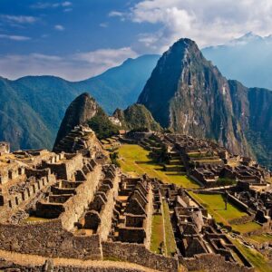 Visitantes en terrazas de Machu Picchu con montañas verdes al fondo