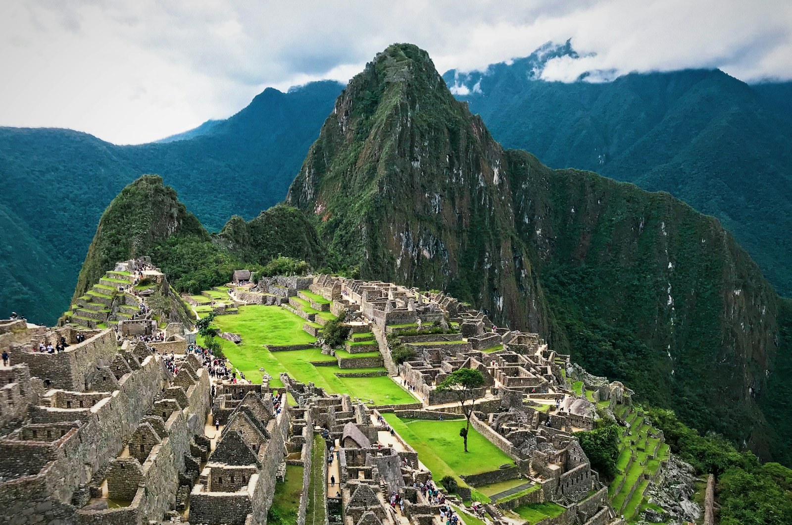Sendero junto a vía férrea en valle verde hacia Machu Picchu Pueblo