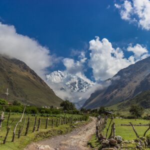 Sendero del Salkantay Trek hacia pico nevado andino bajo cielo azul