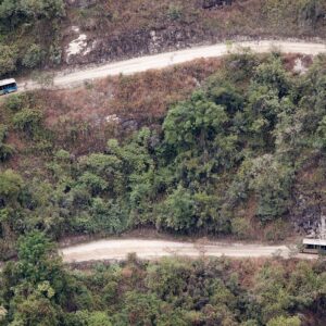 Buses turísticos en la carretera en zigzag que sube desde Aguas Calientes hacia Machu Picchu, entre montañas verdes